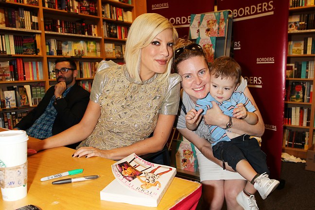 Tori Spelling, gold shimmer top, black leggings, book signing, borders, presenting tallulah